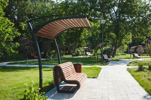 Bancă de parc cu copertină pe o alee